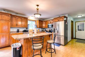 a kitchen with wooden cabinets and a stainless steel refrigerator at Vermont Vacation Rental about 11 Mi to Lake Willoughby in East Charleston