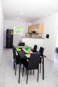 a dining room with a black table and black chairs at Hermosa casa en Costa de Oro in Montería