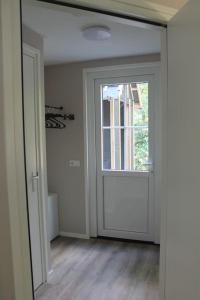 een lege kamer met een deur en een raam bij Kellux vakantiewoning - Heleen in Mariënberg