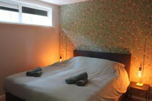een slaapkamer met een bed met 2 kussens erop bij Kellux vakantiewoning - Heleen in Mariënberg