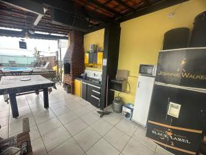 eine Küche mit einer Theke und einem Tisch in einem Zimmer in der Unterkunft Sol & Mar Hostel in Praia Grande