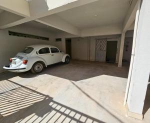 biały samochód zaparkowany w garażu w obiekcie Kitnet Aconchego dos Nobres w mieście Domingos Martins