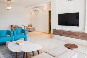 un soggiorno con una TV a schermo piatto su una parete di Mivida Emaar - Residence by Elegant Hospitality a New cairo