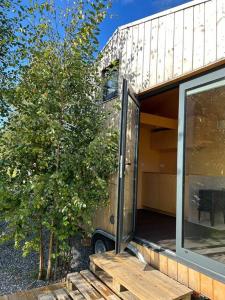 une maison avec une porte coulissante en verre à côté d'un arbre dans l'établissement Little house in Kongsvinger, à Kongsvinger