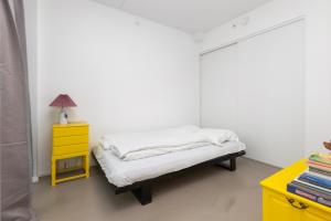 a small bedroom with a bed and a yellow nightstand at Come Stay 50 meter til vand, plads til 6-personer in Aarhus