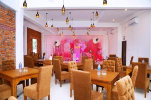 ein Restaurant mit Tischen und Stühlen und einer rosa Wand in der Unterkunft Hotel NorthWay in Vavuniya