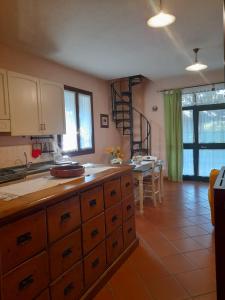 a kitchen with wooden cabinets and a dining room with a table at 8380 Il Tiglio Verde in Manciano