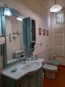 a bathroom with a sink and a toilet and a mirror at 8380 Il Tiglio Verde in Manciano