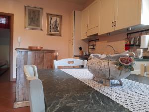 a kitchen with a table with a large vase on it at 8380 Il Tiglio Verde in Manciano