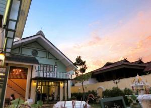 a house with a sunset in the background at Khummuangmin Boutique Hotel Nan in Nan