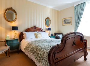 a bedroom with a large bed and two mirrors at The Mount B&B in Keswick