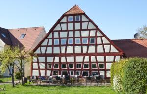 una casa con entramado de madera, mesas y sillas en Holunderblüte, en Colmberg