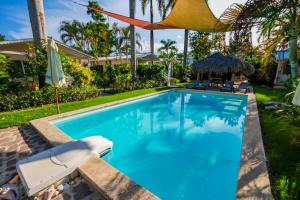 a swimming pool in a yard with a house at Hotel Enjoy in Las Terrenas