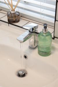 a bottle of soap sitting on a bathroom sink at 8 Karslake Road in Wallasey