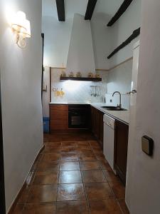 uma cozinha com um lavatório e um fogão forno superior em Casa Rural Moliner em Las Cuevas de Cañart