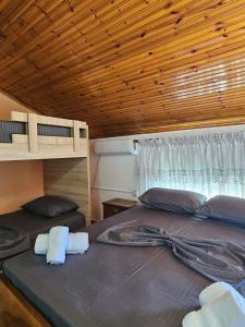 een slaapkamer met 2 bedden en een houten plafond bij Castle Voga Guesthause in Krujë