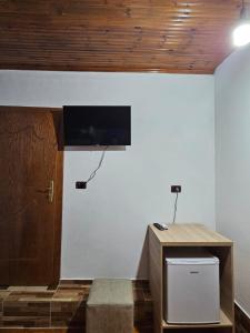 a room with a desk and a tv on a wall at Castle - inside,Voga Guesthause in Krujë