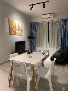 - un salon avec une table et des chaises blanches dans l'établissement LW Suite at JQ Seaview 2BR High Floor & Wi-Fi, à Kota Kinabalu