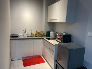 a small kitchen with a sink and a stove at LW Suite at JQ Seaview 2BR High Floor & Wi-Fi in Kota Kinabalu