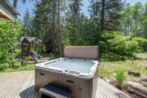 a hot tub on a deck with a chair at Lil Bigfoot Chalet by NW Comfy Cabins in Leavenworth