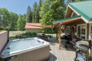a hot tub on a deck next to a house at Lil Bigfoot Chalet by NW Comfy Cabins in Leavenworth