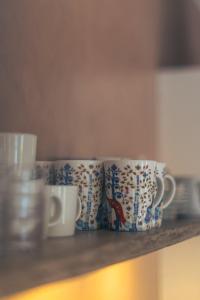 a group of coffee cups sitting on a shelf at Vaxholm Apartment in Vaxholm