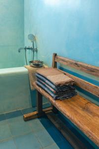 un banco de madera en el baño con bañera en Vaxholm Apartment, en Vaxholm