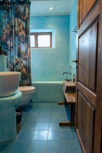 a blue bathroom with a sink and a toilet at Vaxholm Apartment in Vaxholm