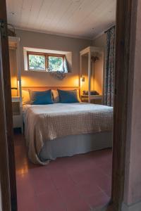 a bedroom with a bed with blue pillows and a window at Vaxholm Apartment in Vaxholm