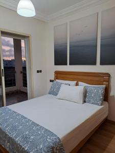 een slaapkamer met een bed met blauwe en witte kussens bij Appartement balnéaire à Sidi Rahal , Maroc in Sidi Rahal