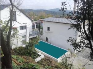 een luchtzicht op een huis met een zwembad bij BayKus Guesthouse-Konukevi in Soke