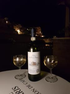 - une bouteille de vin et deux verres sur une table dans l'établissement Affittacamere Chiti Melania, à San Gimignano
