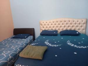 Schlafzimmer mit einem Bett mit blauer Decke in der Unterkunft Homestay Saujana Harmoni D'Petron in Gua Musang