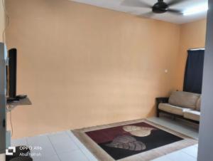a living room with a couch and a rug at Homestay Saujana Harmoni D'Petron in Gua Musang