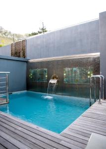 a swimming pool with a water fountain on a building at Selkirk House in Hermanus