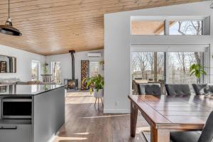 a kitchen and dining room with a wooden ceiling at Le Gaïa - Chalet en nature in Quebec City