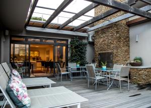a patio with tables and chairs and a brick wall at Selkirk House in Hermanus