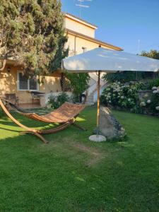 a hammock under an umbrella in a yard at Il Melograno in Arzachena