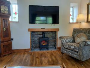 a living room with a fireplace and a television at Rose Cottage Trecynon Traditional 2 bed cottage Zip World Beacons Bike in Aberdare