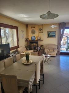 comedor con mesa y sillas y sala de estar en Il Melograno en Arzachena