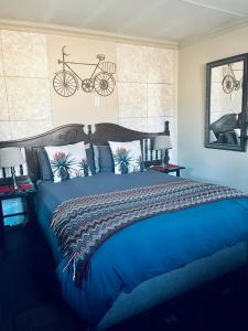 a bedroom with a blue bed with a bike on the wall at Revenir in Middelburg