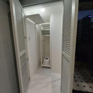 a walk in closet with a door open to a room at Condo Hotel at Greenbelt makati with cityview in Manila