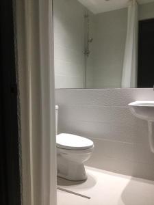een witte badkamer met een toilet en een wastafel bij Condo Hotel at Greenbelt makati with cityview in Manilla