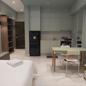 a kitchen with a table and a black refrigerator at Condo Hotel at Greenbelt makati with cityview in Manila