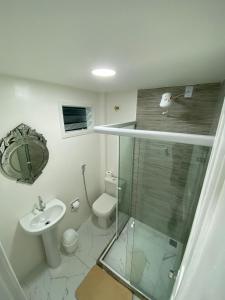 La salle de bains est pourvue d'une douche en verre et de toilettes. dans l'établissement Pousada Lisamar, à Mangaratiba