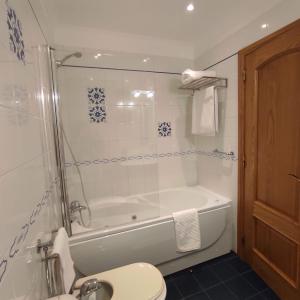 a bathroom with a shower and a tub and a toilet at Casa Santa Maria - Tomar in Tomar