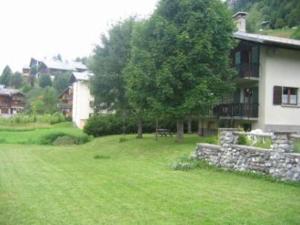 a house with a tree and a grass yard at Appartement Les Gets, 4 pièces, 6 personnes - FR-1-671-99 in Les Gets