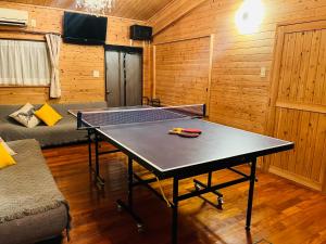 a ping pong table in the middle of a room at Lodge Crea in Ujimi