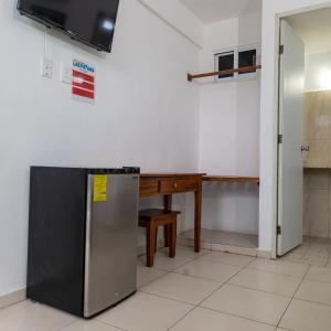 a kitchen with a desk and a refrigerator at Hotel Las Palmas en Laurel in Cancún +35 photos