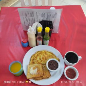 a plate of food with toast and coffee on a red table at Hotel Las Palmas en Laurel in Cancún